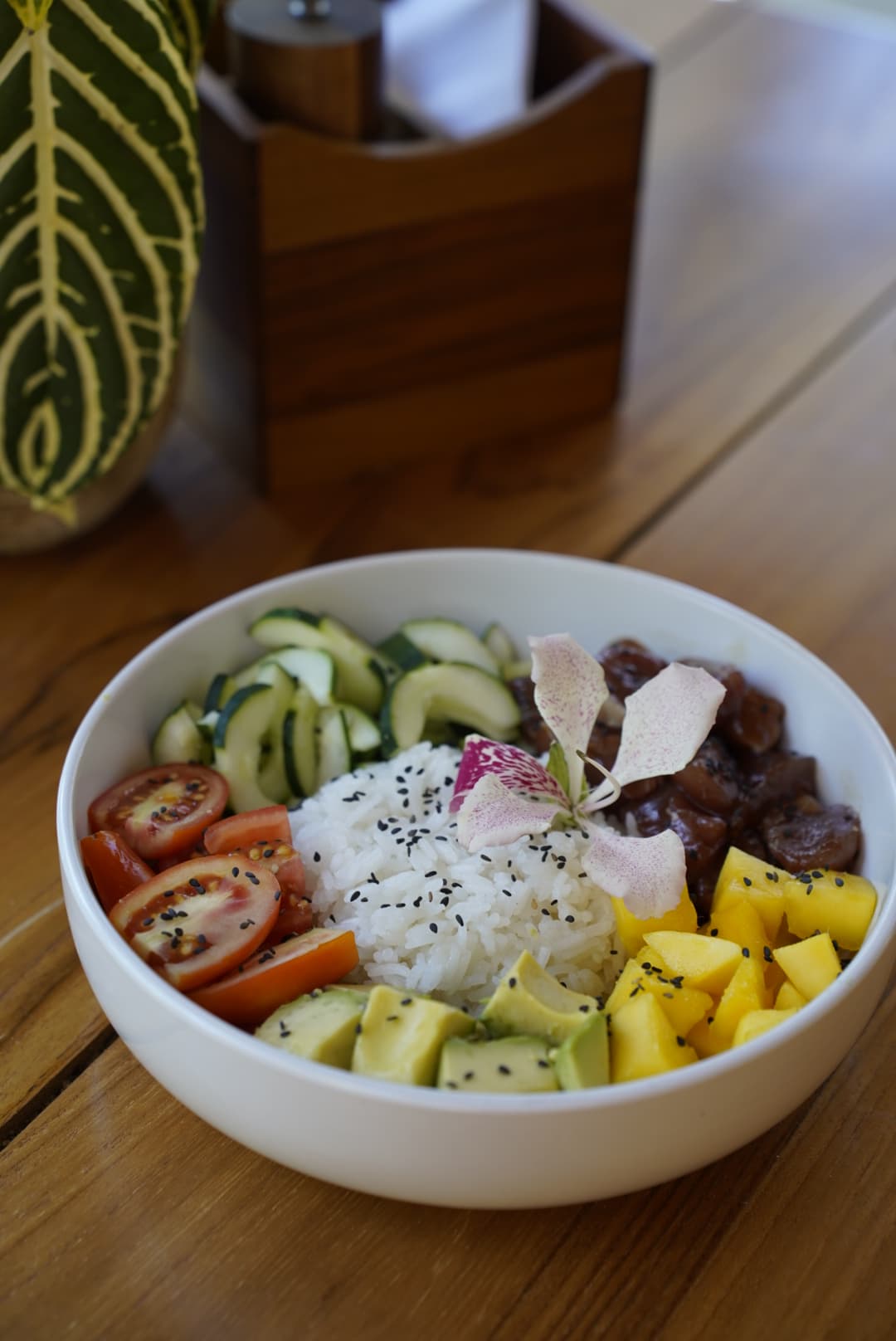 Rice bowl with avocado, mango and an orchid
